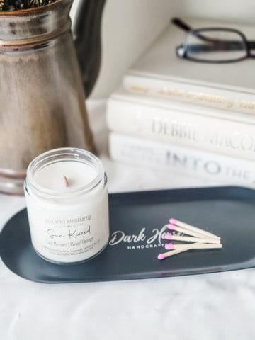 Lifestyle pic of sun kissed candle on matte black candle tray